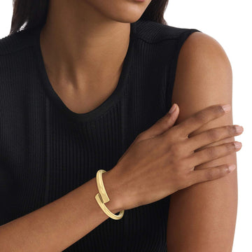 Γυναικείο Βραχιόλι Χειροπέδα Calvin Klein 35000763 ατσάλινο χρυσό με ασσύμετρο σχέδιο, φορεμένο.